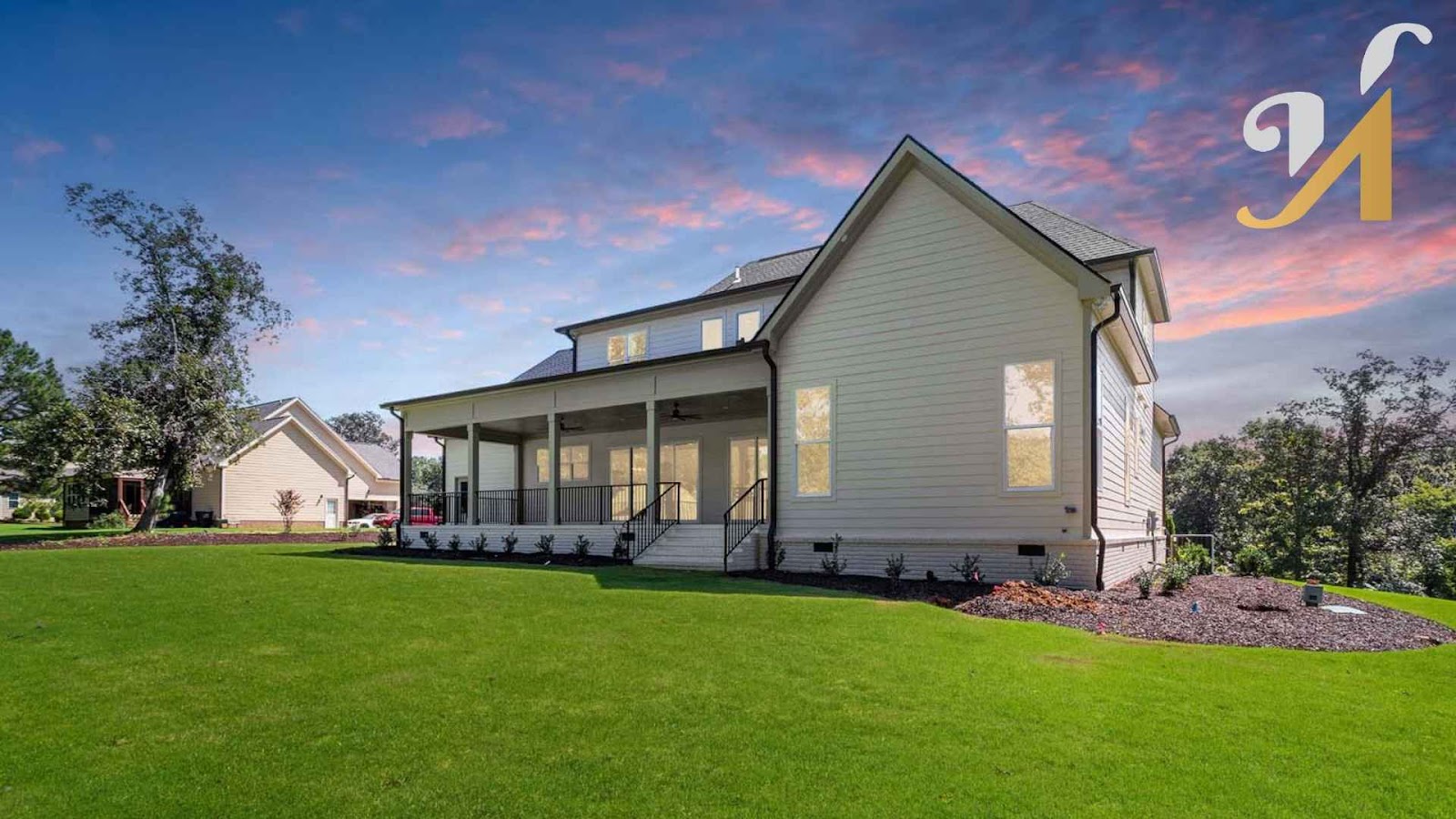 Modern house with spacious green lawn at sunset.