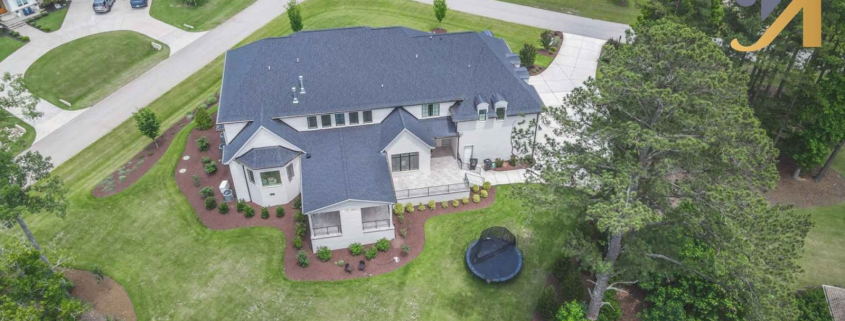 Aerial view of suburban house with yard and trees.