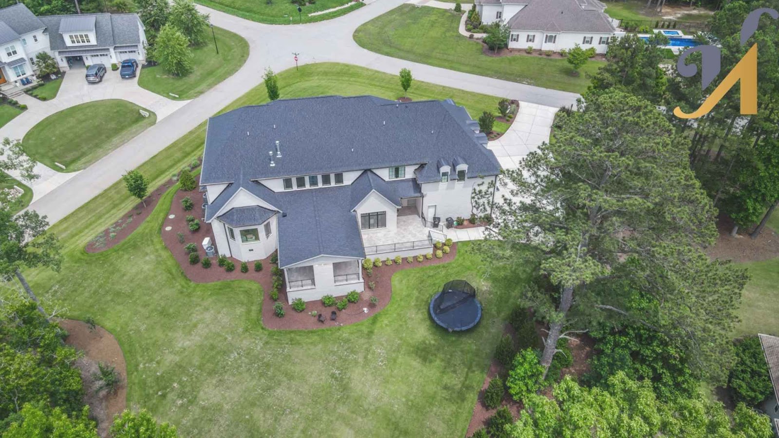 Aerial view of suburban house with yard and trees.