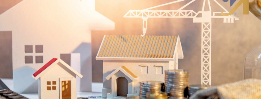 Models of houses with construction crane and coins.