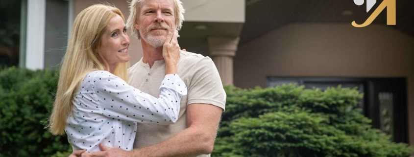 Elderly couple embracing outdoors near house
