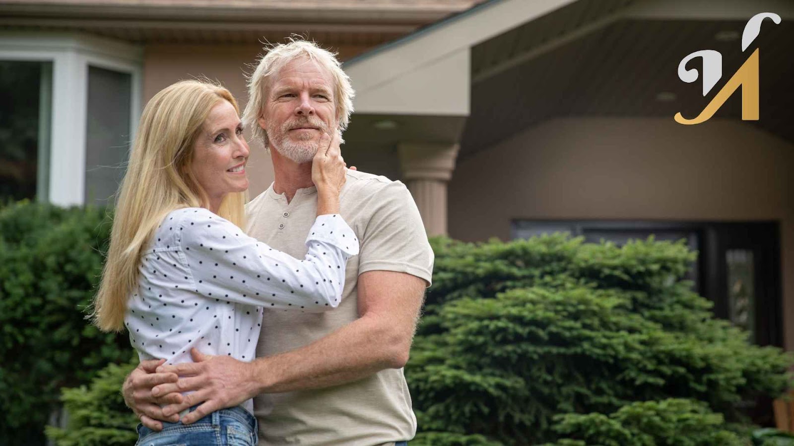 Elderly couple embracing outdoors near house
