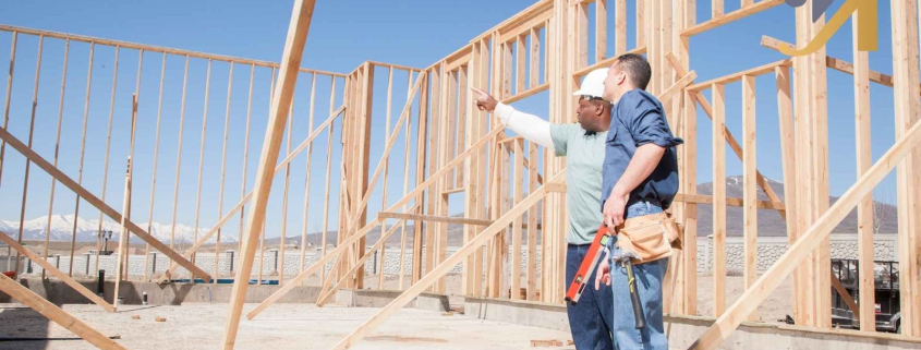 Construction workers examining wooden framework on site